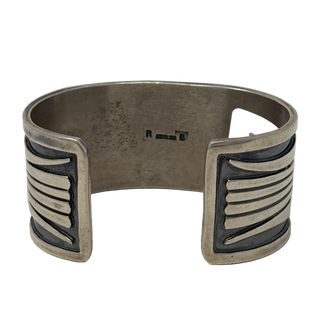 Silver cuff bracelet with geometric design on a white background