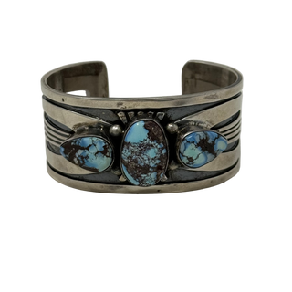 Silver bracelet with turquoise stones on a light gray background